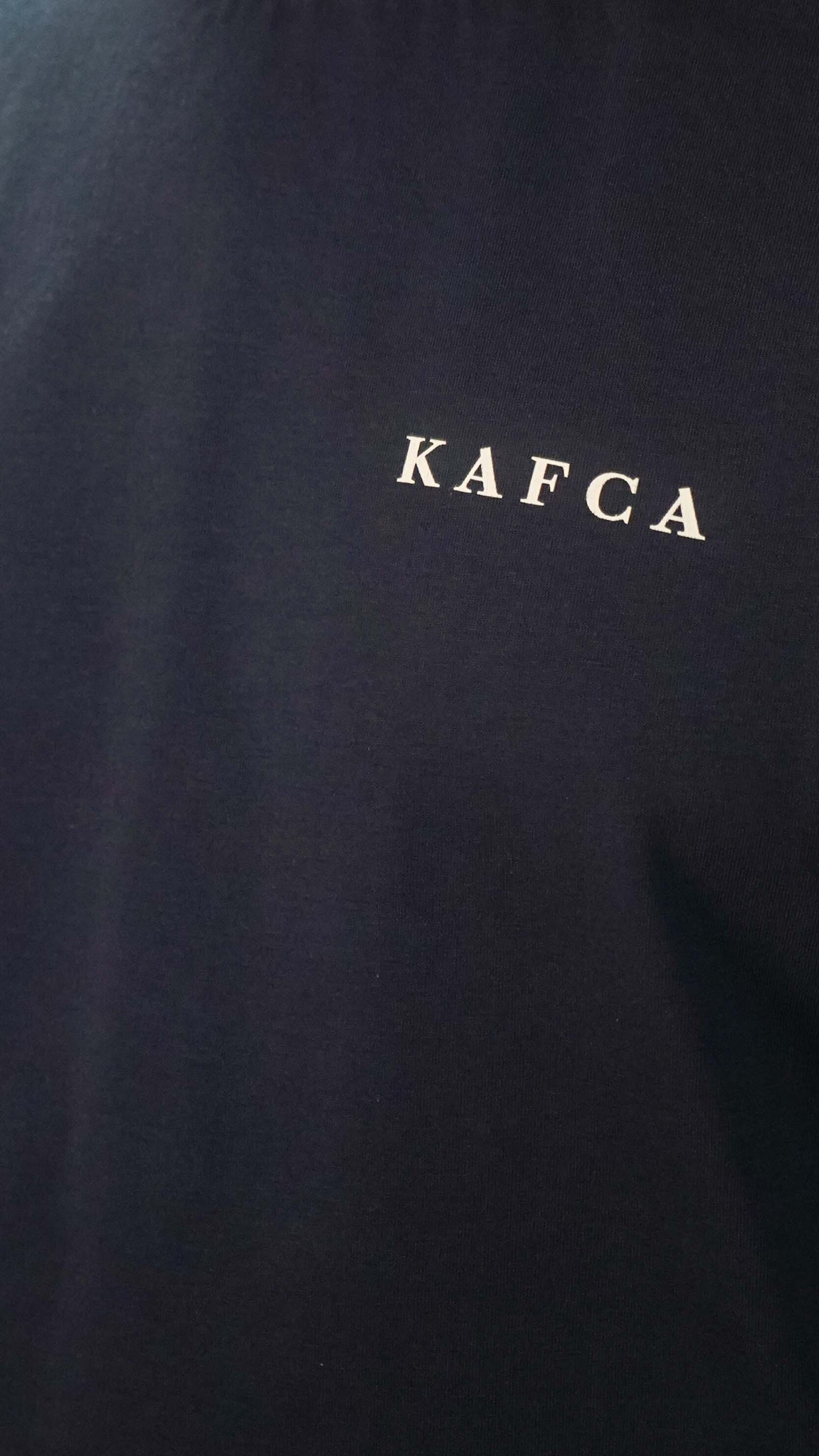 KAFCA-Couture T-Shirt in navy von vorne mit KAFCA-Schriftzug in beige als Detailaufnahme