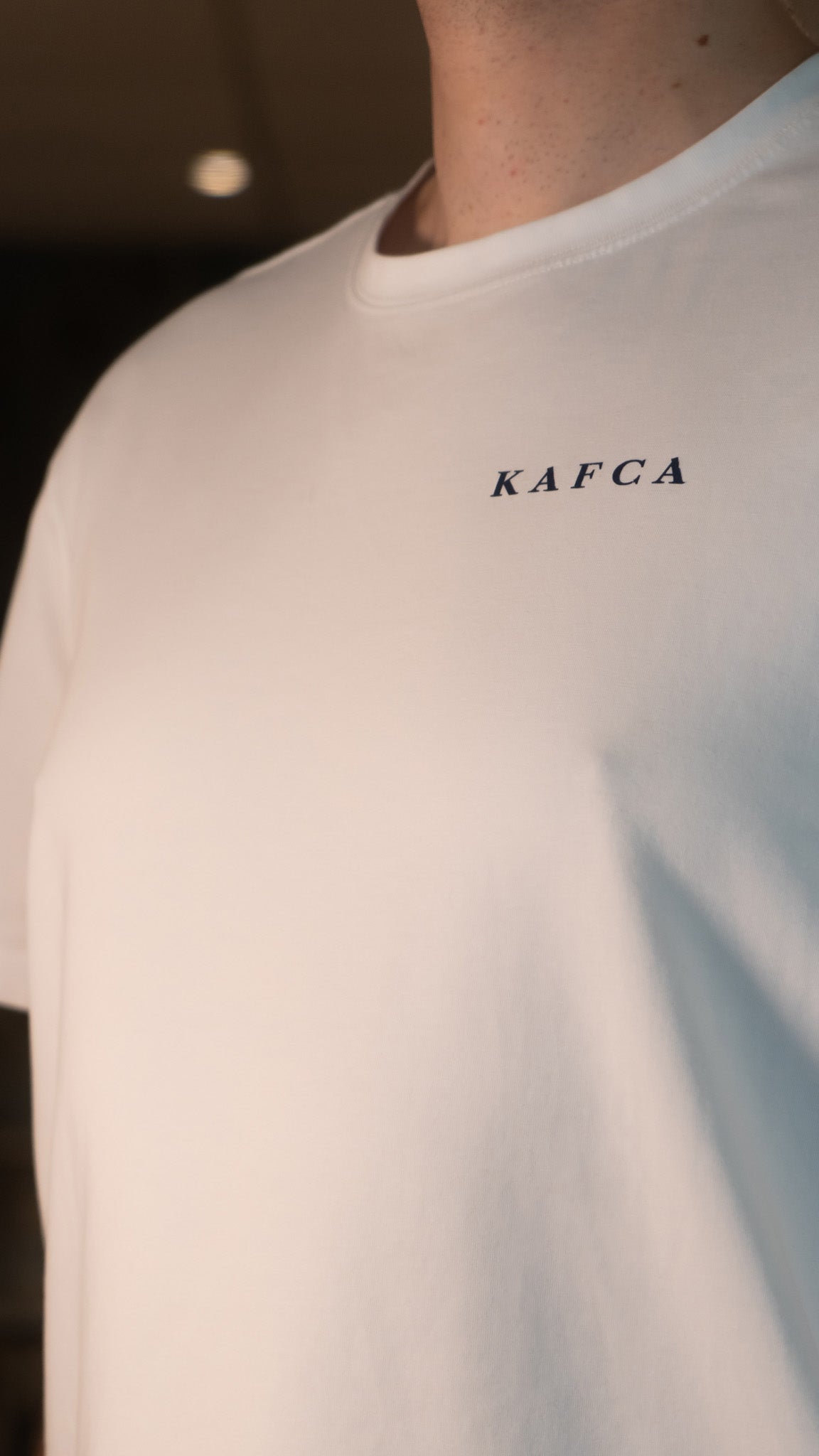 KAFCA-Couture T-Shirt in weiß von vorne mit KAFCA Logo in blauem Druck Nahaufnahme